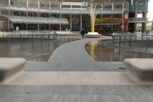 Foto della piazza con lo specchio d'acqua centrale e un percorso pedonale a raso di andamento curvilineo
